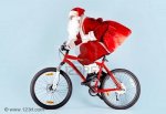 8227564-photo-of-happy-santa-claus-with-red-sack-riding-bike.jpg