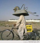 hombre-en-bicicleta-llevando-carretilla-como-casco.jpg